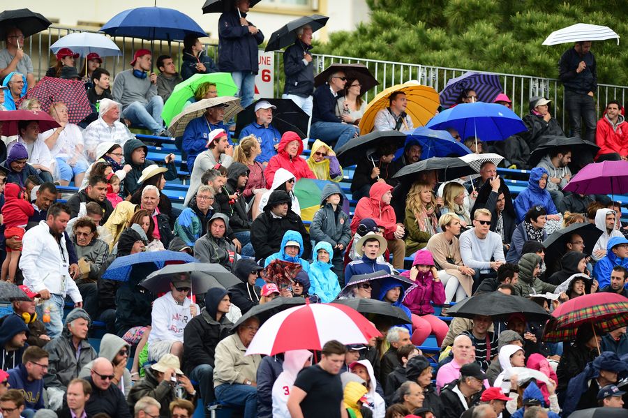 Fans at grandstands open umbrellas as start raining