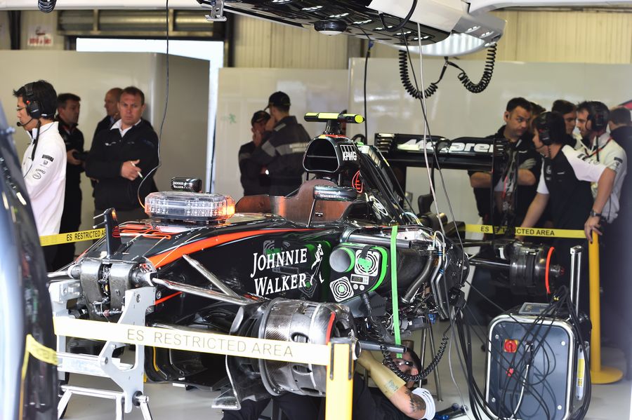 McLaren mechanics work on the Jenson Button's car