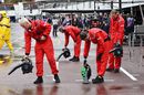 Manor Marussia mechanics try to dry the pit box up with blowers