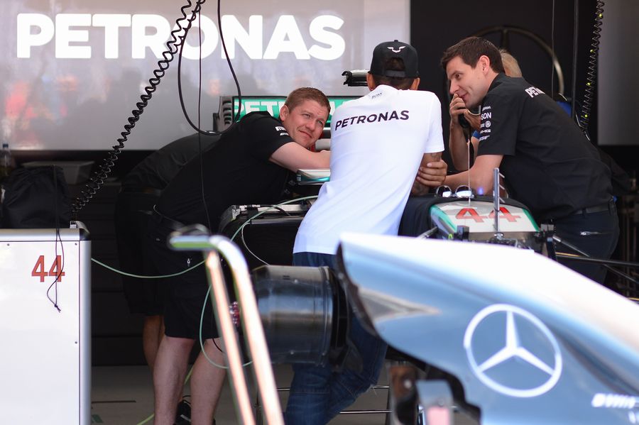 Lewis Hamilton chats with engineers in the Mercedes garage