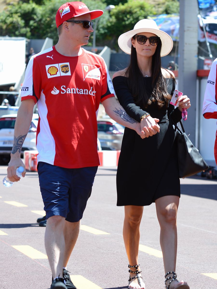 Kimi Raikkonen walks down the paddock with his wife Minttu Virtanen
