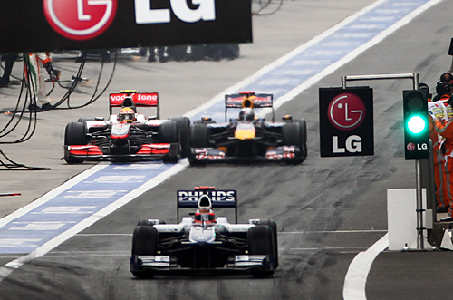 Sebastian Vettel and Lewis Hamilton battle as they leave the pit lane