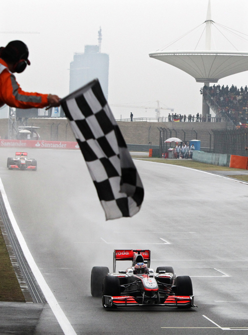 Jenson Button takes the chequered flag