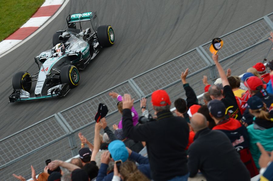 Lewis Hamilton waves to fans from the cockpit
