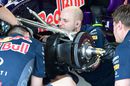 Red Bull mechanics work on front brake and wheel hub of the RB11