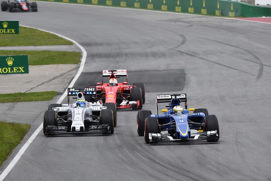 Felipe Massa and Marcus Ericsson battle for a position while coming up by Sebastian Vettel