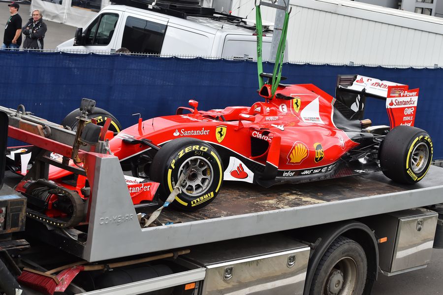 Sebastian Vettel's SF15-T is returned to the pits on a flatbed truck in FP1