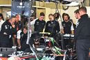 McLaren mechanics work on Jenson Button's MP4-30 in the garage