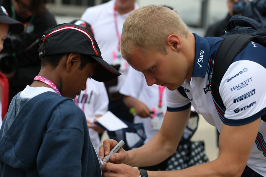 Valtteri Bottas signs autographs for a young fan