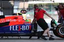 Manor Marussia mechanics wheel Roberto Merhi into the garage