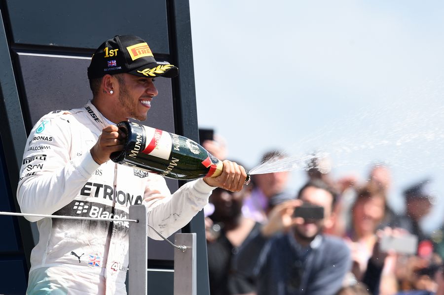 Lewis Hamilton celebrates on the podium with champagne