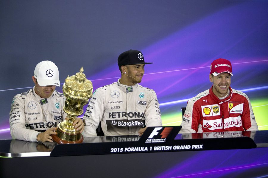 Nico Rosberg looks Lewis Hamilton's trophy during the press conference