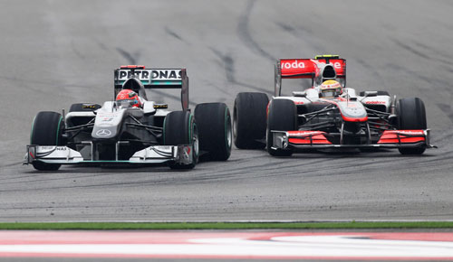 Michael Schumacher comes under pressure from Lewis Hamilton