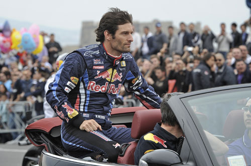 Mark Webber sits on the back of a car as he gets ready to take part in the Red Bull F1 Show Run