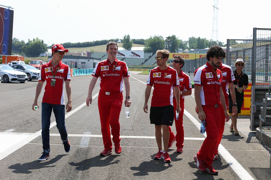 Sebastian Vettel and Esteban Gutierrez walks the track with Ferrari members
