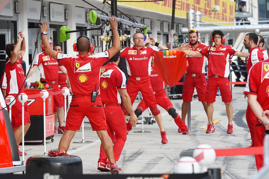 Ferrari mechanics warming up for pitstop practice