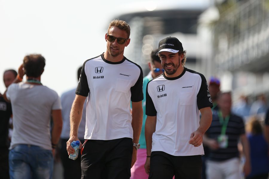 Jenson Button and Fernando Alonso walk through the paddock