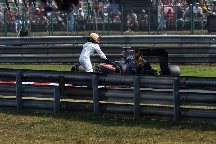 Fernando Alonso pushes his MP4-30 after engine failure in Q2