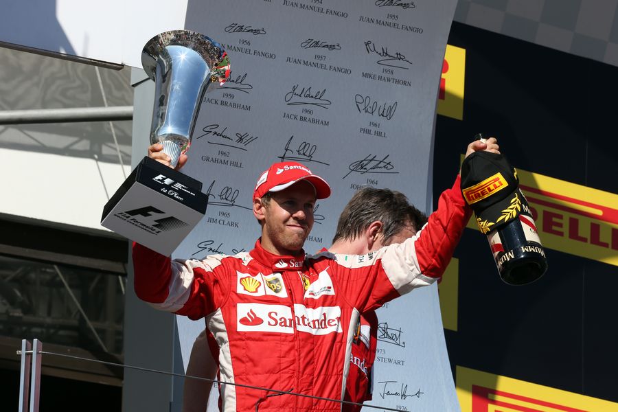Sebastian Vettel celebrates his win with the trophy on the podium