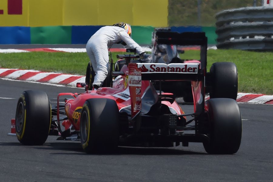 Sebastian Vettel passes Fernando Alonso pushing his car