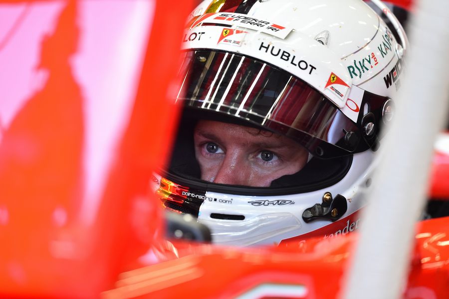 Sebastian Vettel sits in the Ferrari cockpit
