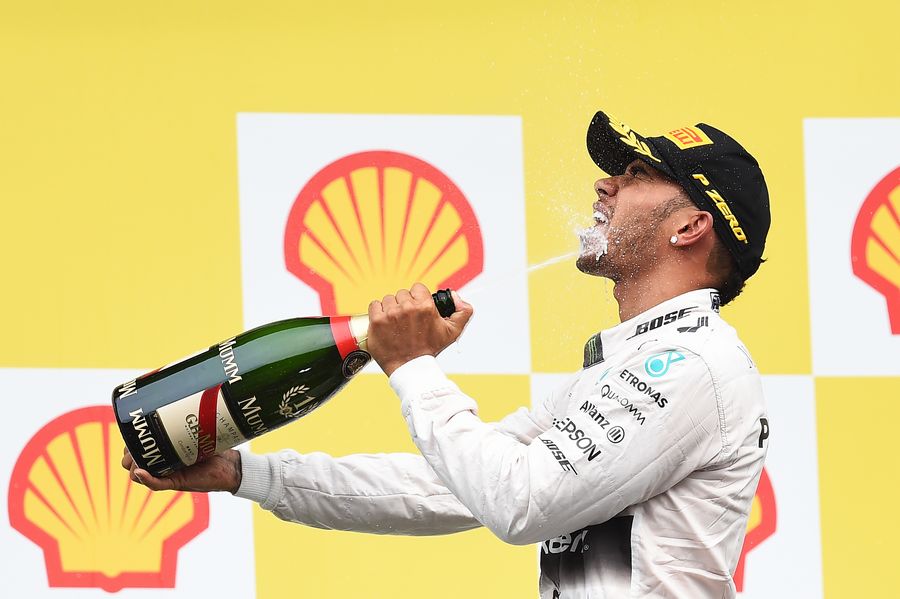 Lewis Hamilton celebrates his win on the podium with the champagne