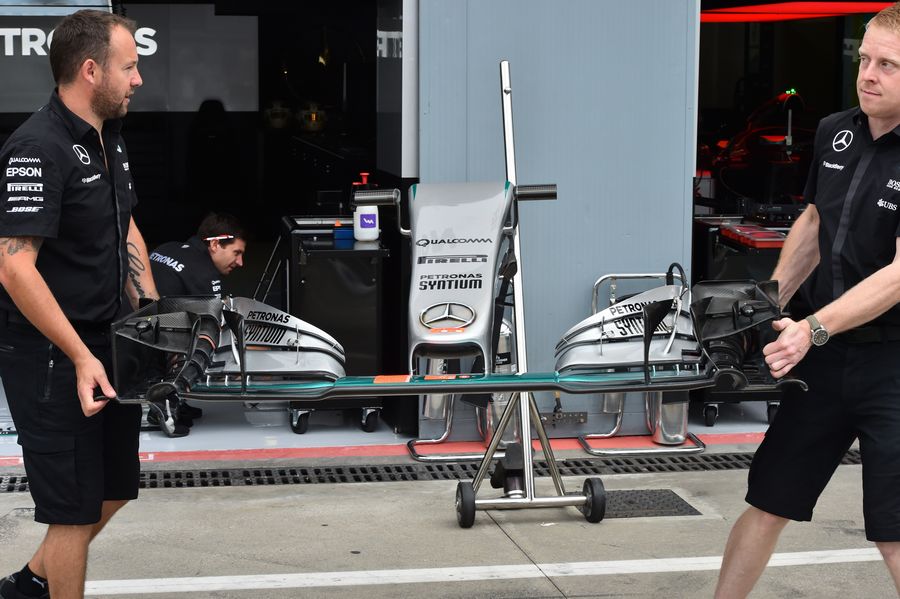 Mercedes mechanics carry a front wing of W06