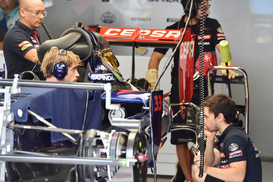 Toro Rosso mechanics work on STR10 in the garage