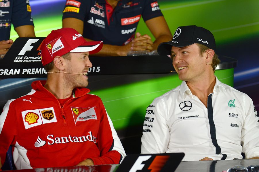 Sebastian Vettel and Nico Rosberg share a joke at the press conference