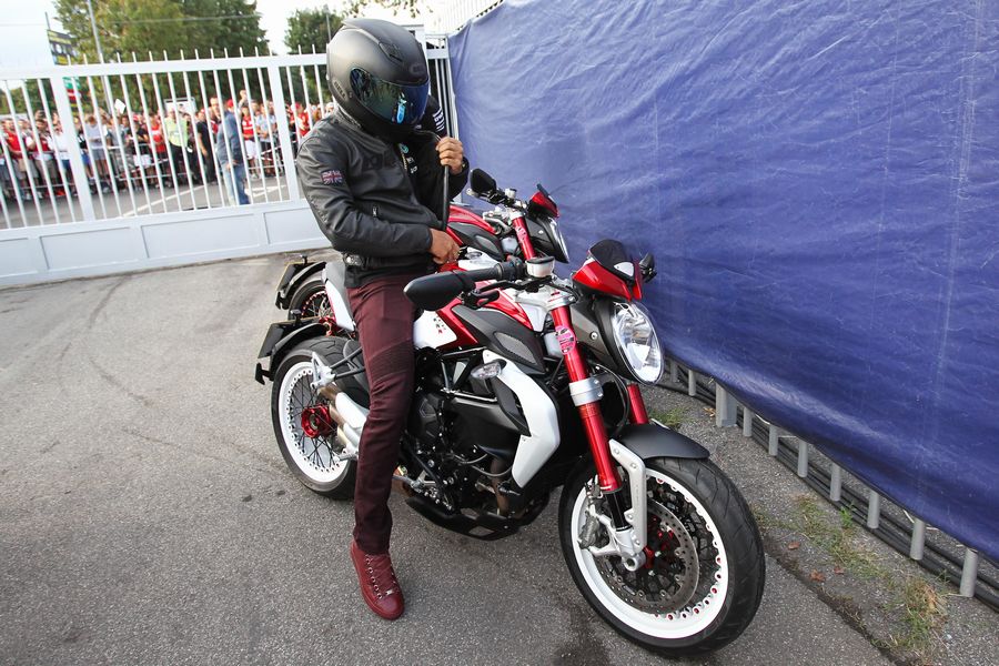 Lewis Hamilton arrives on his motorbike