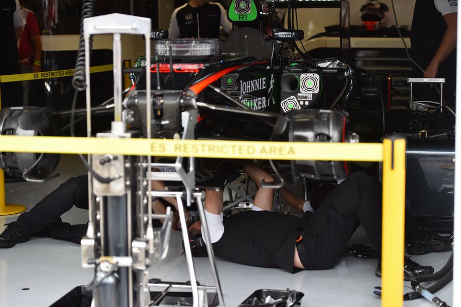 Mechanics work on the car of Jenson Button's MP4-30