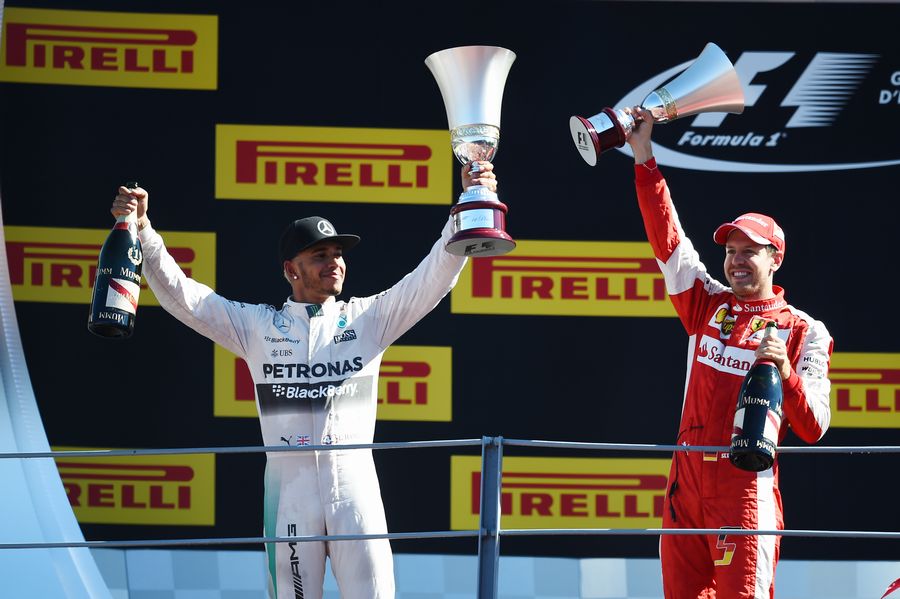 Lewis Hamilton and Sebastian Vettel celebrate on the podium with the trophies