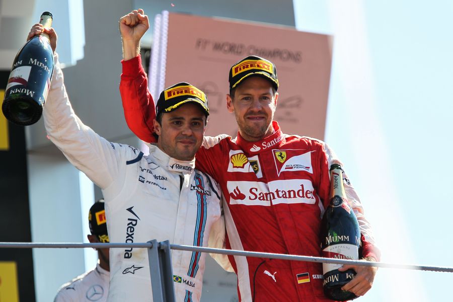 Sebastian Vettel and Felipe Massa celebrate on the podium with champagne