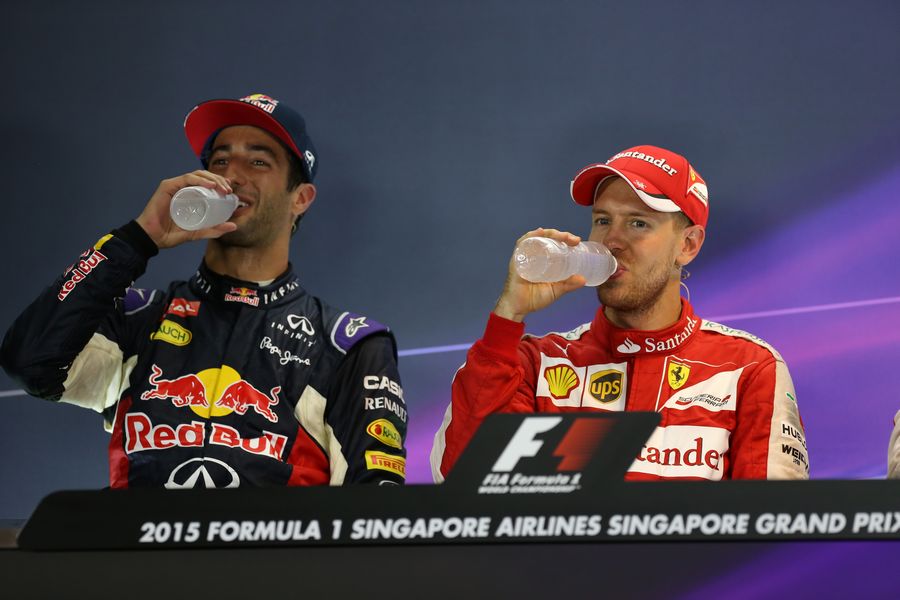Daniel Ricciardo and Sebastian Vettel drink walter after a tough race