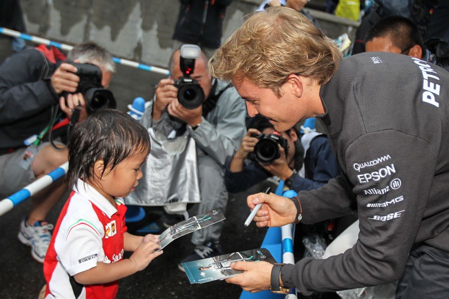 Nico Rosberg signs autographs for a young fan
