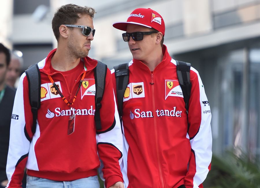 Sebastian Vettel and Kimi Raikkonen walk through the paddock