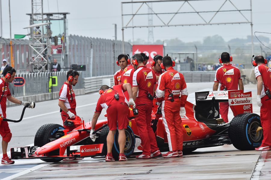 Ferrari mechanics wheel Kimi Raikkonen back into the garage