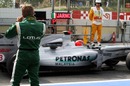 Heikki Kovalainen watches Michael Schumacher leave the pits