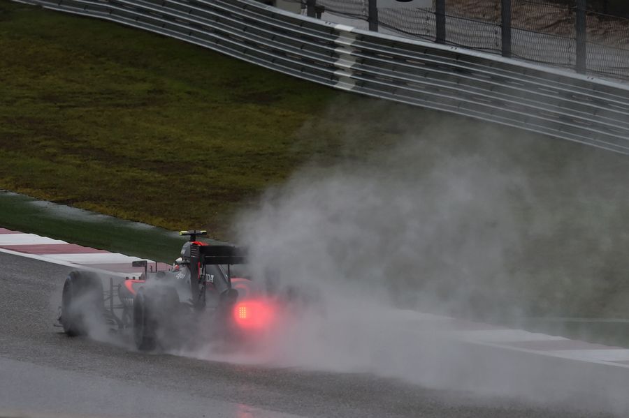 Jenson Button drives through the spray