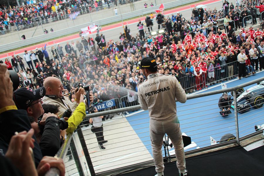 Lewis Hamilton shares some of champagne with fans