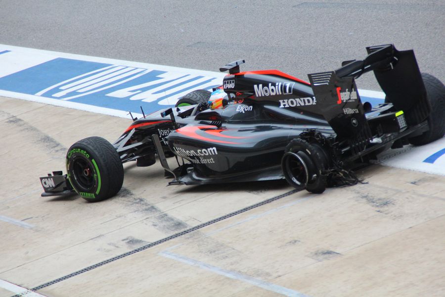Fernando Alonso rushes to the pit to change his punctured rear tyre