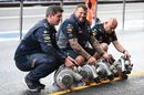 Red Bull mechanics dry the pit box