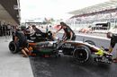 Force India mechanics wheel Sergio Perez back into the garage