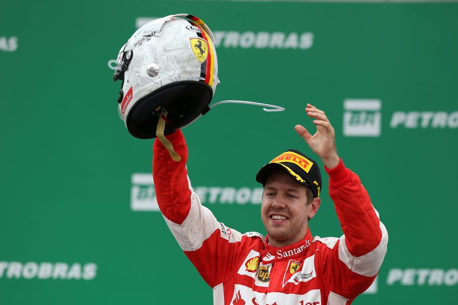Sebastian Vettel celebrates on the podium with his helmet