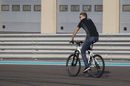 Nico Hulkenberg rides a bike on the track