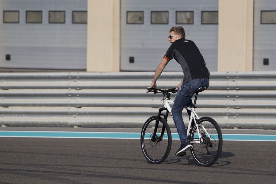 Nico Hulkenberg rides a bike on the track