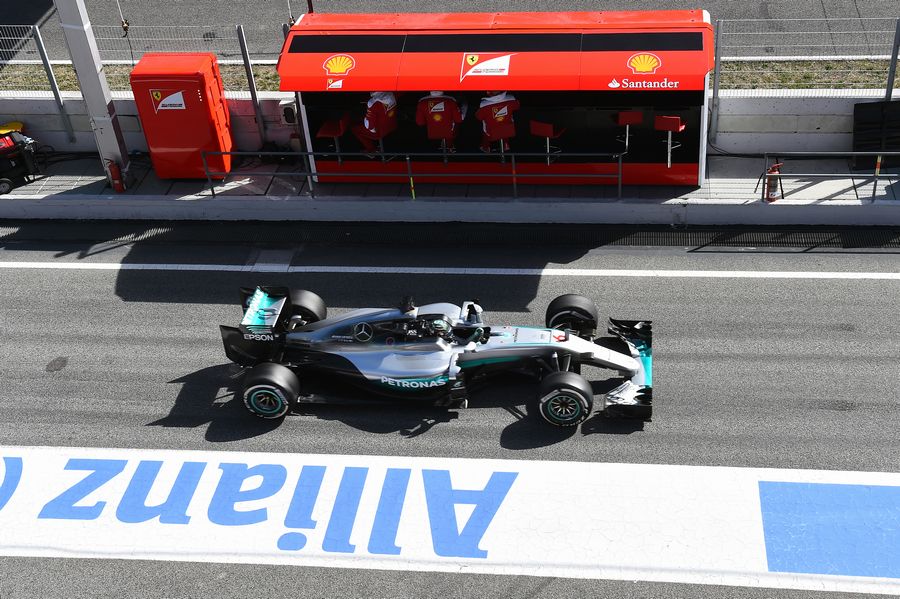 Nico Rosberg passes the Ferrari pit wall