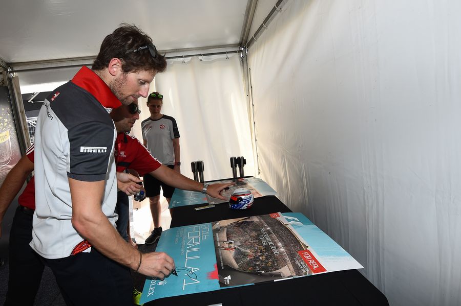 Romain Grosjean signs posters