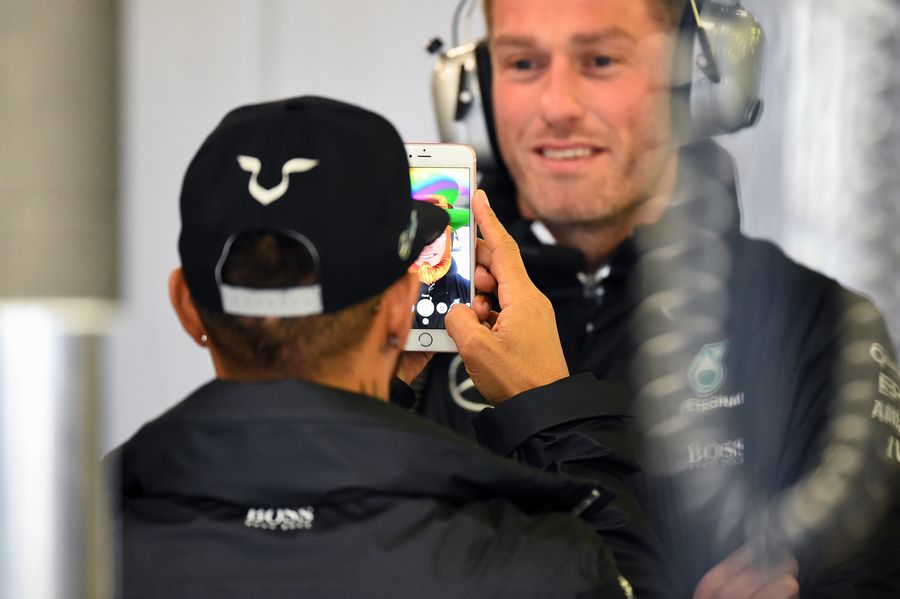 Lewis Hamilton takes a photograph on his iPhone