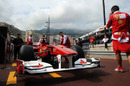 Mechanics push a Ferrari in the pitlane